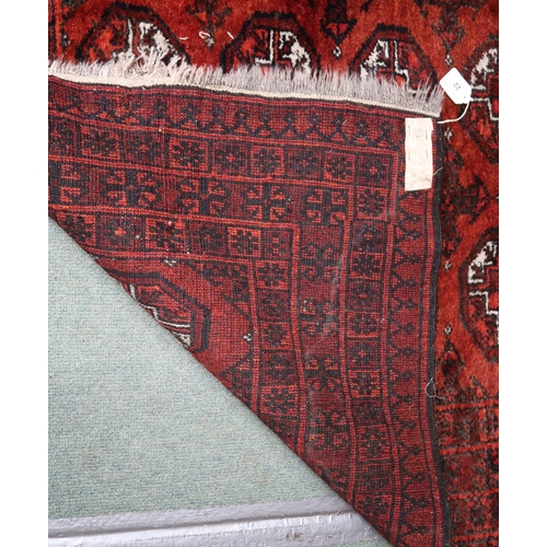 22 - A red ground Bokhara rug with lozenge design and multiple borders, 140cm long x 109cm wide 