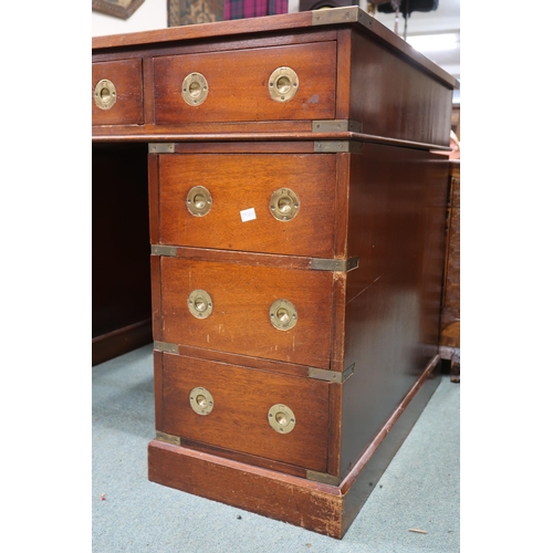 26 - A 20th century campaign style pedestal writing desk with embossed skiver over three drawers on three... 