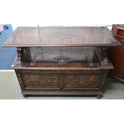 32 - A 20th century oak monks hall bench with hinged top on lion form arms over hinged chest base carved ... 