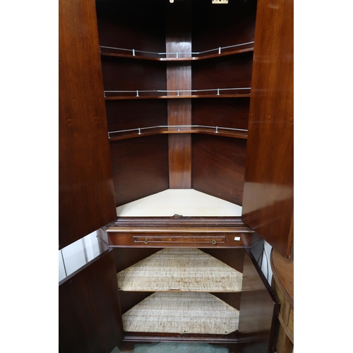 33 - A 20th century mahogany corner drinks cabinet with dentil cornice over pair of panel door concealing... 