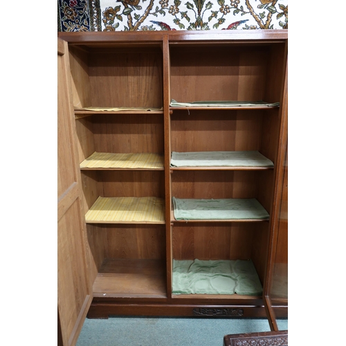 39 - A 20th century Oriental hardwood bookcase with central glazed door flanked by cabinet doors on plint... 