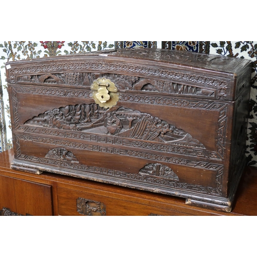 40 - A 20th century Chinese camphorwood domed top blanket chest extensively carved with village scenes on... 