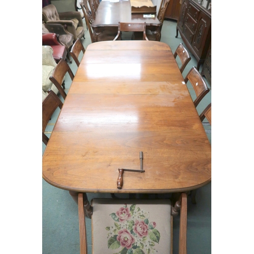 43 - A Victorian wind out extending dining table and eight sabre legged dining chairs, table with two spa... 