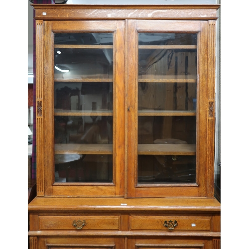 64 - A late Victorian oak bookcase with moulded cornice over pair of glazed doors on base with two drawer... 