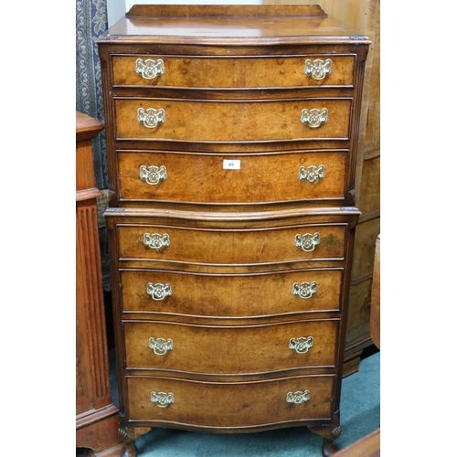 65 - A 20th century mahogany and walnut veneered serpentine front chest on chest with three drawers over ... 