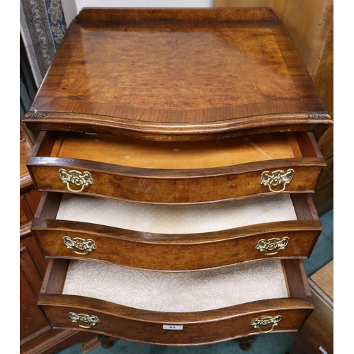 65 - A 20th century mahogany and walnut veneered serpentine front chest on chest with three drawers over ... 