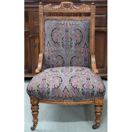 91 - A Victorian oak framed nursing chair with damask upholstery on turned supports terminating in cerami... 