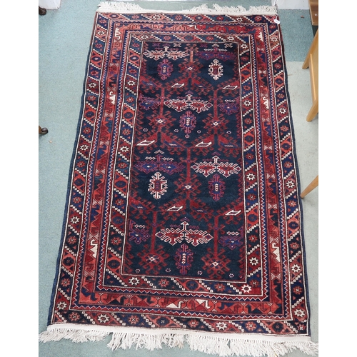 97 - A dark blue ground Balouch rug with geometric central design and multiple multicoloured 209cm long x... 