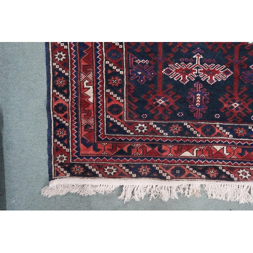 97 - A dark blue ground Balouch rug with geometric central design and multiple multicoloured 209cm long x... 