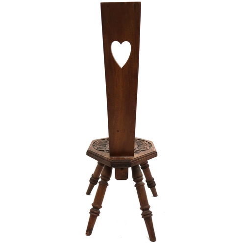 2033 - AN EARLY 20TH CENTURY CARVED OAK SPINNING CHAIR back rest pierced with heart shaped decoration over ... 