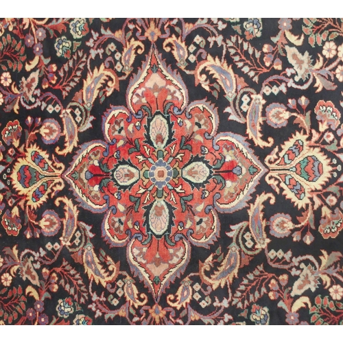 2131 - A BLACK FLORAL FOLIATE PATTERNED GROUND LILIHAN RUG with red central medallion, matching spandrels a... 