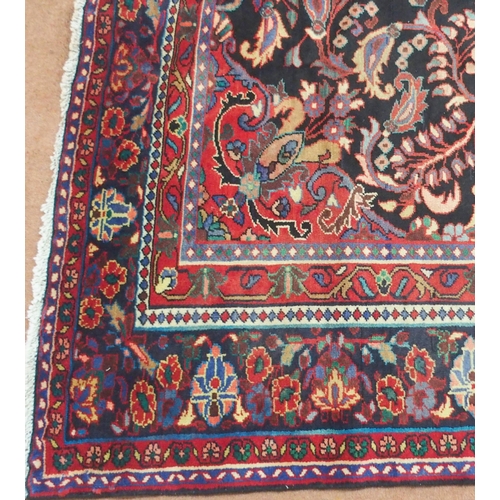 2131 - A BLACK FLORAL FOLIATE PATTERNED GROUND LILIHAN RUG with red central medallion, matching spandrels a... 