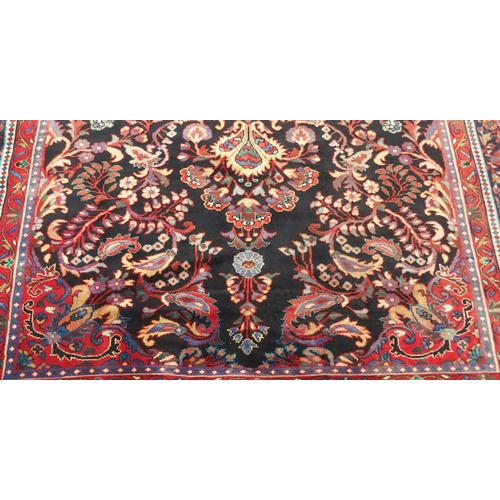 2131 - A BLACK FLORAL FOLIATE PATTERNED GROUND LILIHAN RUG with red central medallion, matching spandrels a... 