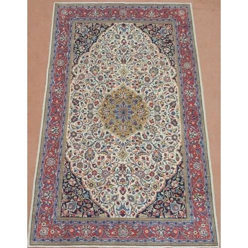 2132 - A CREAM FLORAL PATTERNED GROUND SAROUGH RUG with mustard central medallion, dark blue spandrels and ... 