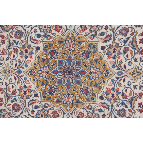 2132 - A CREAM FLORAL PATTERNED GROUND SAROUGH RUG with mustard central medallion, dark blue spandrels and ... 