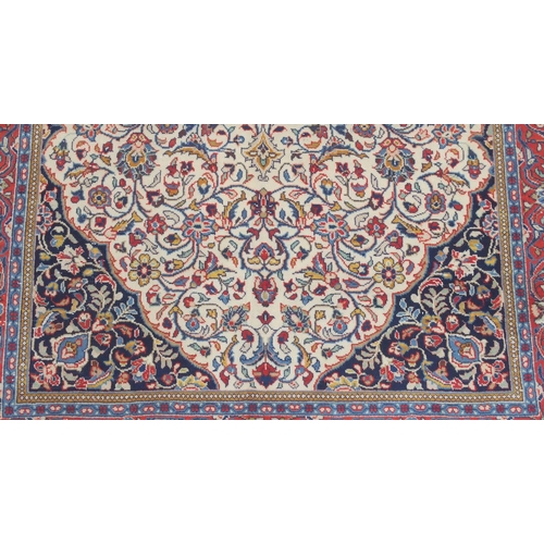 2132 - A CREAM FLORAL PATTERNED GROUND SAROUGH RUG with mustard central medallion, dark blue spandrels and ... 