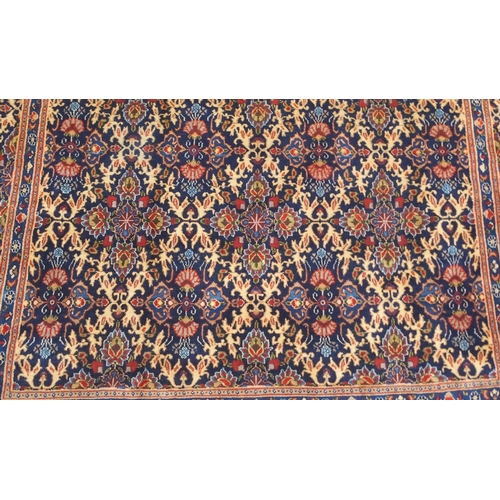 2133 - A DARK BLUE GROUND MOOD RUG with all-over medallion design and multiple coloured borders, 302cm long... 