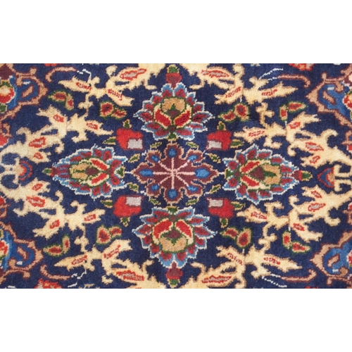 2133 - A DARK BLUE GROUND MOOD RUG with all-over medallion design and multiple coloured borders, 302cm long... 