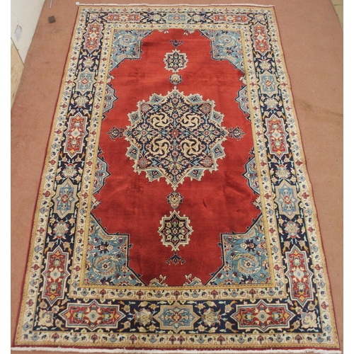 2134 - A RED GROUND TABRIZ RUG with dark blue central medallion, light blue spandrels and dark blue borders... 