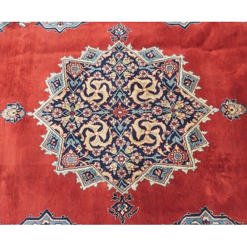 2134 - A RED GROUND TABRIZ RUG with dark blue central medallion, light blue spandrels and dark blue borders... 