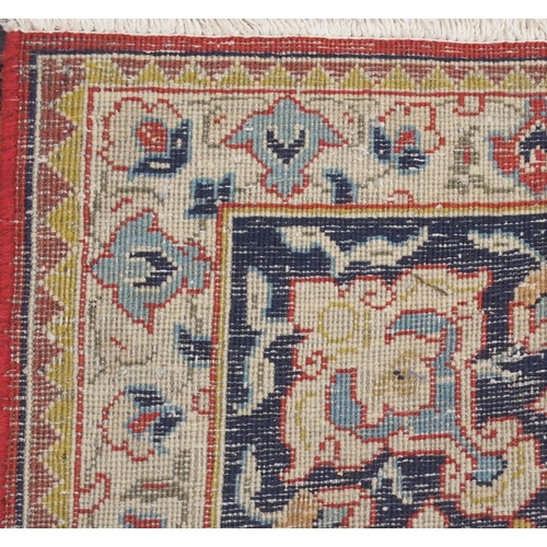 2134 - A RED GROUND TABRIZ RUG with dark blue central medallion, light blue spandrels and dark blue borders... 