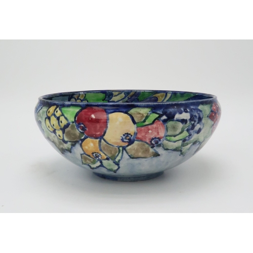 2188 - ELIZABETH MARY WATT (SCOTTISH 1886-1954)A bird and fruit painted bowl, with blue ground, initialled ... 