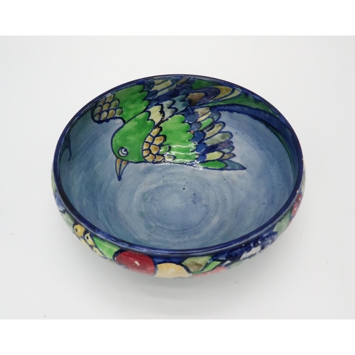 2188 - ELIZABETH MARY WATT (SCOTTISH 1886-1954)A bird and fruit painted bowl, with blue ground, initialled ... 