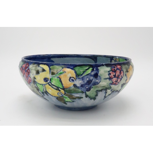 2188 - ELIZABETH MARY WATT (SCOTTISH 1886-1954)A bird and fruit painted bowl, with blue ground, initialled ... 