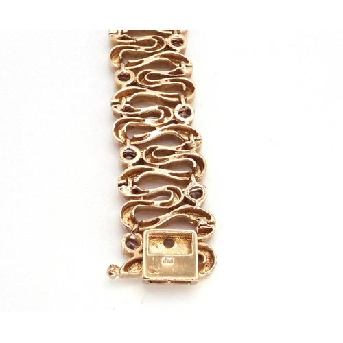 2701 - A 9CT GOLD WAVE PATTERN BRACELETinterspaced with sparkling cubic zirconia, length of the bracelet 18... 