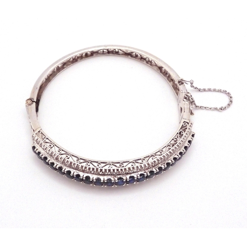 2702 - A SAPPHIRE AND DIAMOND BRACELET in 18k white gold set with twenty one oval sapphires tapering i... 