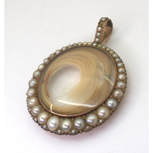 2720 - A VICTORIAN PEARL SET LOCKETthe rose-coloured mount with double sided glazed panel containing two lo... 