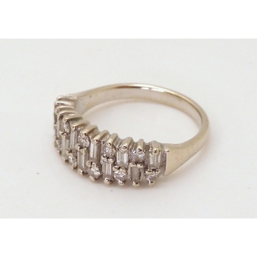 2724 - AN 18CT ETERNITY RINGAn 18ct white gold baguette and brilliant cut half eternity ring, set with esti... 