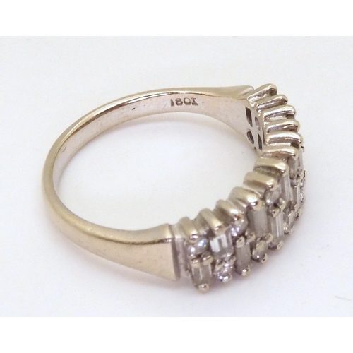 2724 - AN 18CT ETERNITY RINGAn 18ct white gold baguette and brilliant cut half eternity ring, set with esti... 