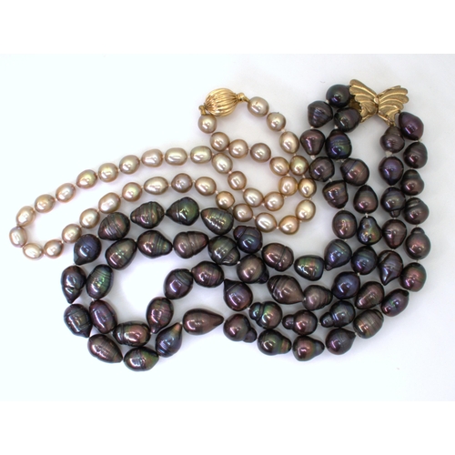 2733 - TWO GOOD STRINGS OF PEARLSa double string of black baroque pearls with a 9ct gold butterfly shaped c... 