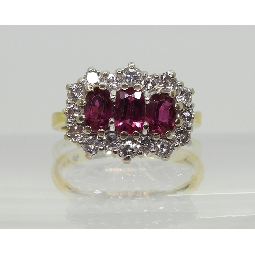 2738 - A RUBY AND DIAMOND RING18ct gold set with three rubies, largest approx. 6mm x 3.7mm x 2.6mm, smaller... 