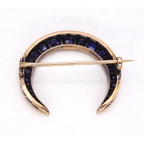 2759 - A CRESCENT MOON BROOCHset with sapphires to the galleried mount. Largest sapphire approx 5mm x 4.6mm... 