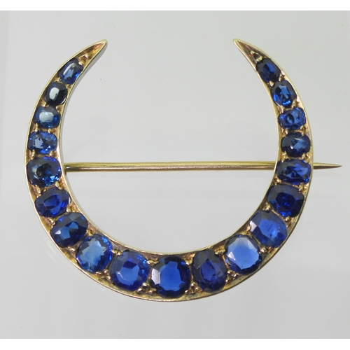 2759 - A CRESCENT MOON BROOCHset with sapphires to the galleried mount. Largest sapphire approx 5mm x 4.6mm... 