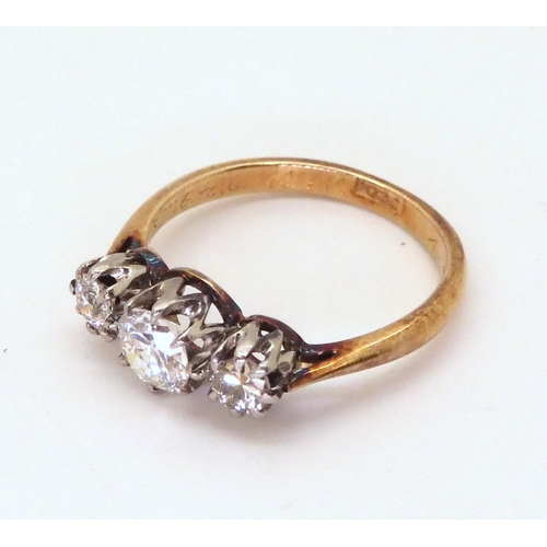 2761 - A THREE STONE DIAMOND RINGthe 18ct yellow and white gold mount is set with three old cut diamonds wi... 