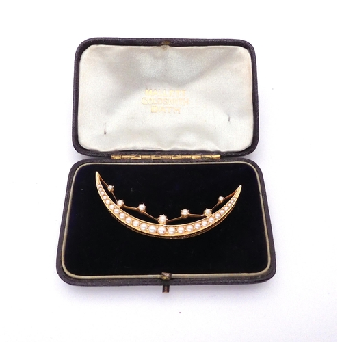 2764 - A CRESCENT MOON BROOCHthe bright yellow metal galleried mount set with split pearls throughout with ... 