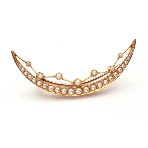 2764 - A CRESCENT MOON BROOCHthe bright yellow metal galleried mount set with split pearls throughout with ... 