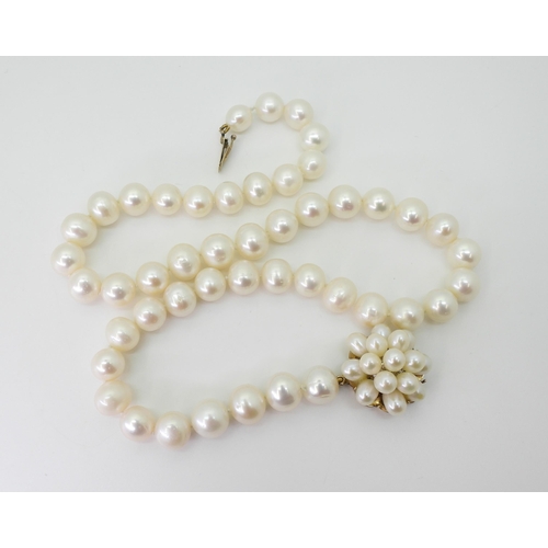 2782 - A STRING OF WHITE BAROQUE PEARLSeach pearl approx 10.2mm, with a yellow metal pearl flower clasp, le... 