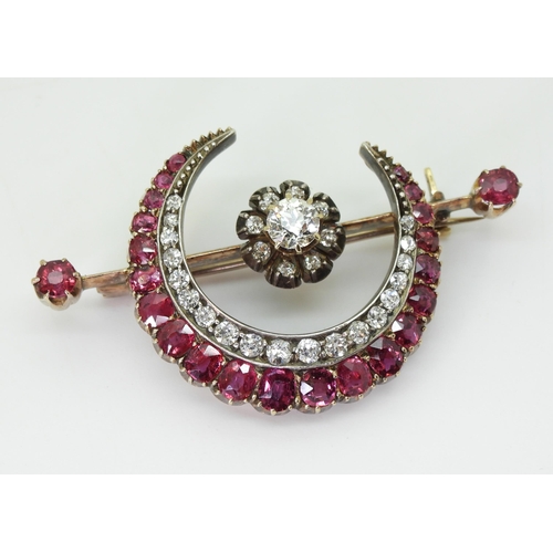 2835 - A SUBSTANTIAL CRESCENT MOON BROOCHset with diamonds and rubies to the crescent, central flower and t... 