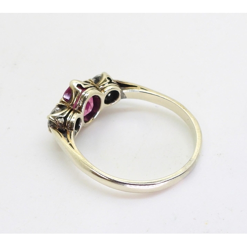 2841 - A PINK SAPPHIRE AND DIAMOND RINGmounted in white metal with decorative crown mounts, the two diamond... 