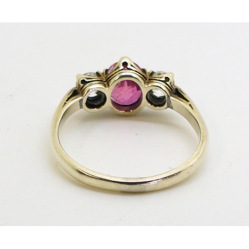 2841 - A PINK SAPPHIRE AND DIAMOND RINGmounted in white metal with decorative crown mounts, the two diamond... 