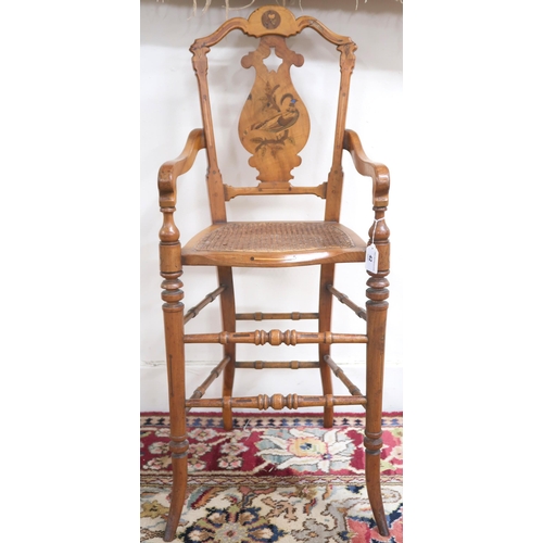 42 - A Victorian walnut framed bergere children's high chair with shaped splat inlaid with game bird over... 