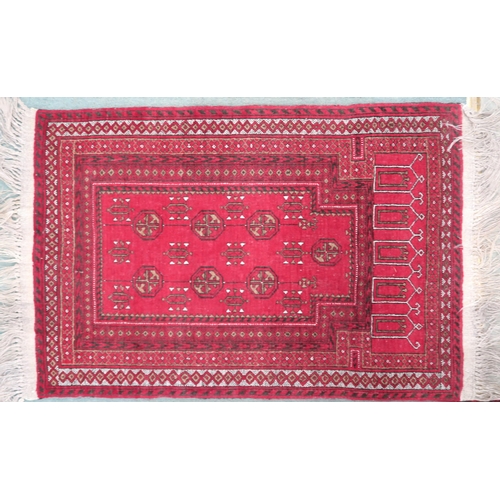 66 - A red ground Bokhara style prayer mat/rug with multiple borders, 122cm long x 79cm wide 