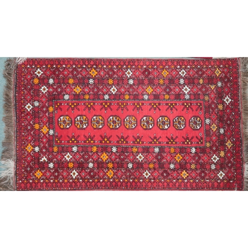 67 - A red ground Bokhara rug with lozenge design and multiple multicoloured borders, 148cm long x 85cm w... 