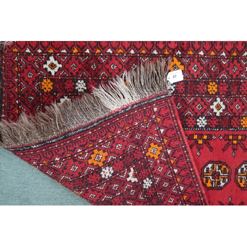 67 - A red ground Bokhara rug with lozenge design and multiple multicoloured borders, 148cm long x 85cm w... 