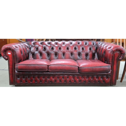 73 - A 20th century oxblood leather buttonback upholstered Chesterfield style three seater sofa, 68cm hig... 