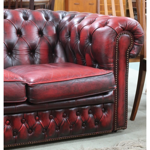 73 - A 20th century oxblood leather buttonback upholstered Chesterfield style three seater sofa, 68cm hig... 